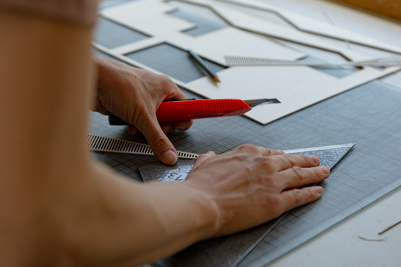 person cutting out forms of material